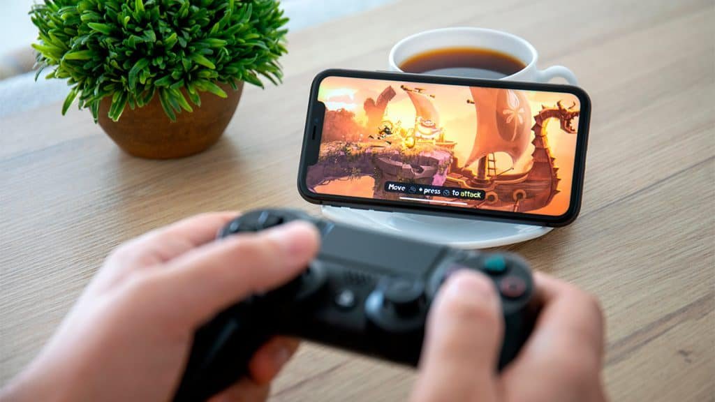 Person playing on iPhone using PlayStation 4 control