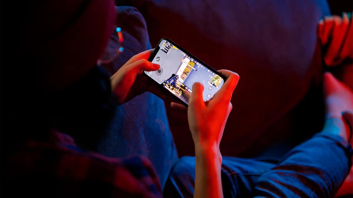 Person playing retro game on iPhone