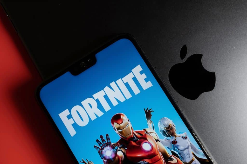 Fortnite open on a smartphone next to Apple device