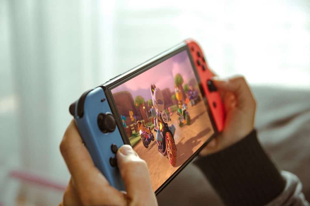 Young man playing with a portable console Nintendo Switch.