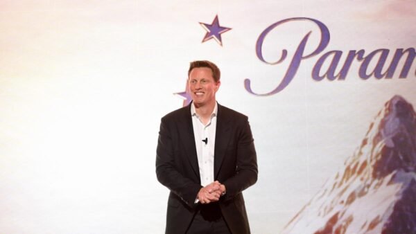 david ellison stands on stage at with Paramount logo as backdrop during 2026 upfronts event